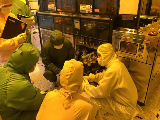 충북 음성 충북반도체고의 '옐로우베이'에서 학생들이 반도체 표면에 설계도가 그려지는 과정을 배우고 있다. 반도체 부품에 영향을 덜 주기 위해 파장이 큰 노란색 형광등을 써 '옐로우베이'라 부른다. 사진 충북반도체고