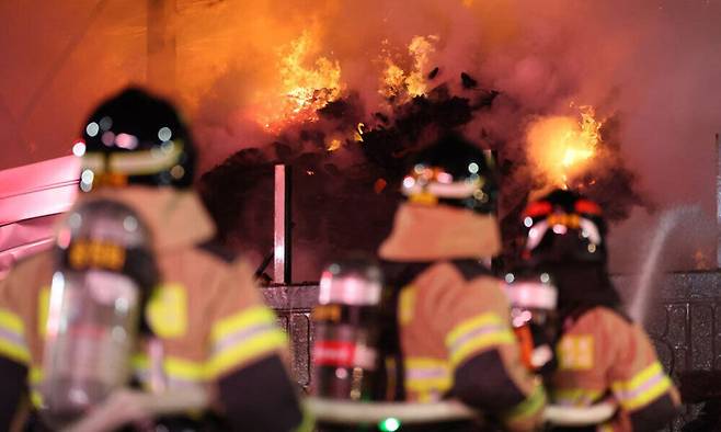 한 업체 야적장에서 화재가 발생해 소방관들이 진화 작업을 하고 있다. 연합뉴스