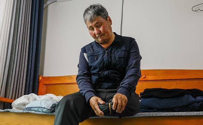 지난 10일 전북 전주시 완산구 평화동 자택에서 전직 환경미화원 김석곤(70)씨가 절단된 왼쪽 다리를 바라보고 있다. 김씨는 2년 전 새벽 음식물쓰레기 수거 업무 중 뺑소니 사고로 다리를 잃었다.&nbsp; &nbsp;전주=최상수 기자