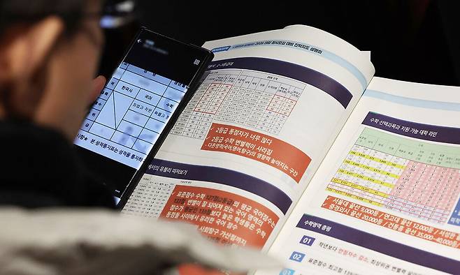 13일 오전 서울 성북구 고려대 인촌기념관에서 열린 서울시교육청 2026 대입 정시모집 대비 진학설명회를 찾은 수험생 학부모가 입시 설명 자료를 살펴보고 있다. 뉴스1