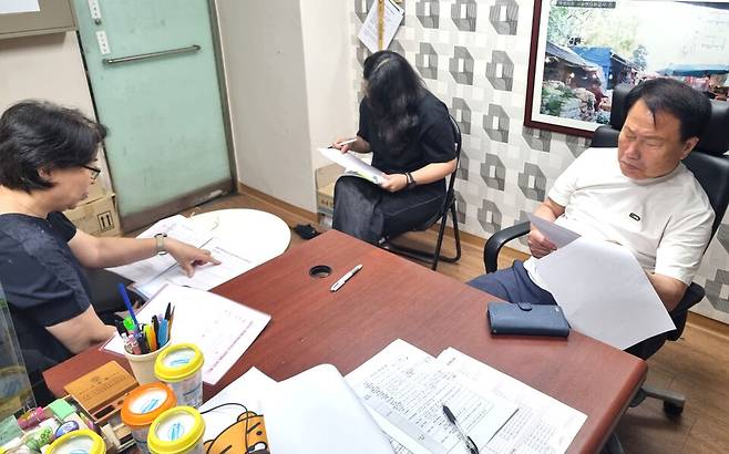 ▲&nbsp;옥련시장은 올해 문화관광형시장 공모 준비에 나섰다. 사진은 회의 중인 이상덕 옥련시장상점가진흥사업협동조합 상인회장과 시장매니저의 모습. /사진제공=옥련시장
