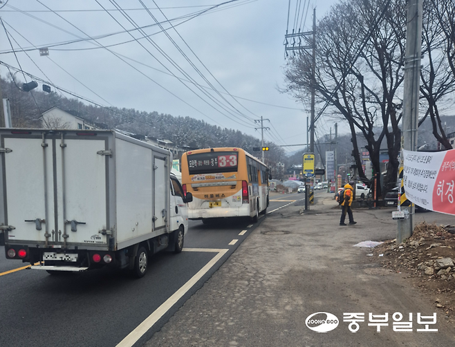15일 광주시 목현동 왕복 1차선인 이배재도로에 설치된 한 버스승강장에서 버스가 정차하자 뒤따르던 차량이 멈춰 서서 통행을 기다리고 있다. 김동욱기자