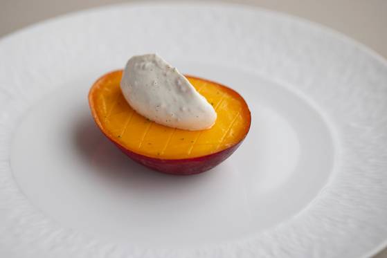 세잔의 시그니처 디저트 ‘미야자키 망고와 쇼트브레드,크렘 샹티이’. 망고 반쪽 위에 크림을 올린 듯 단순해보이지만 그 안에는 망고, 쇼트 브레드, 소르베까지 정교하게 쌓여 있다. [사진 세잔]