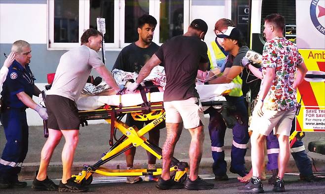 호주 시드니 인근 본다이 해변에서 14일 무장 용의자가 총기를 난사해 용의자 1명을 포함해 최소 12명이 사망했다. 응급 구조대원들이 총격 부상자를 이송하고 있다.﻿ AP연합뉴스