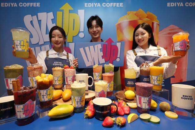 16일 서울 중구 이디야커피 IBK본점에서 모델들이 음료 용량 확대와 메뉴 라인업 개편을 알리는 '사이즈 업&라인 업' 행사를 알리고 있다. 연합뉴스