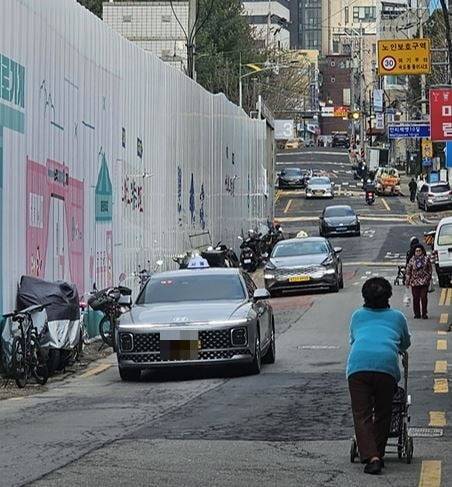 지난 15일 서울 마포구 공덕동 서울서부지방법원 뒤편 언덕길에서 노인들이 보행 공간이 막혀 차도로 내려와 이동하고 있다. 권용훈 기자