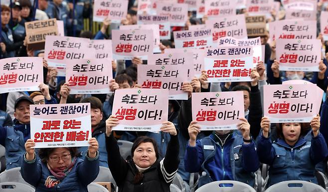 택배노동자들이 지난달 23일 서울 광화문 동십자각 앞에서 열린 ‘과로사 없는 택배 만들기 시민대행진’에 앞서 구호를 외치고 있다. [뉴스1]