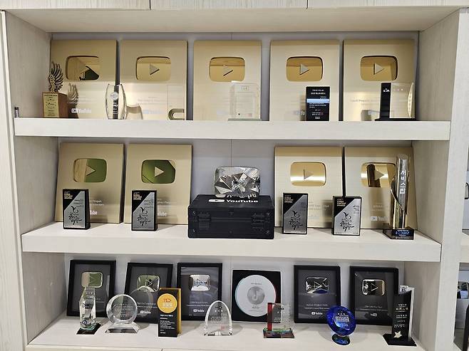 최종일 아이코닉스 대표 집무실 한편에 자리한 유튜브 크리에이터 어워즈 상패. 가입자 100만 돌파시 수여되는 골드 버튼과 1000만 돌파시 수여되는 다이아몬드 버튼(가운데)이 놓여있다. 최은지 기자.