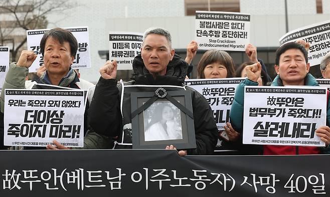 Vu Van Sung (center), father of Tu Ahn, holds a portrait of his daughter during a protest in front of the presidential office in central Seoul on Dec. 9. (Yonhap)