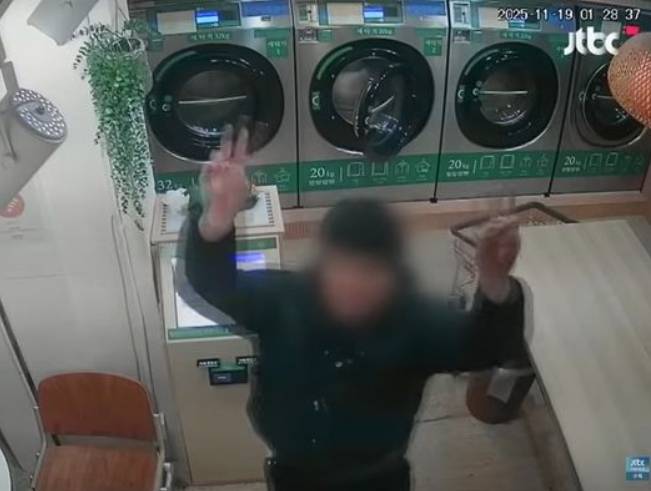 A middle school student poses in front of a security camera after stealing from an unmanned laundry shop in Seoul. [SCREEN CAPTURE]
