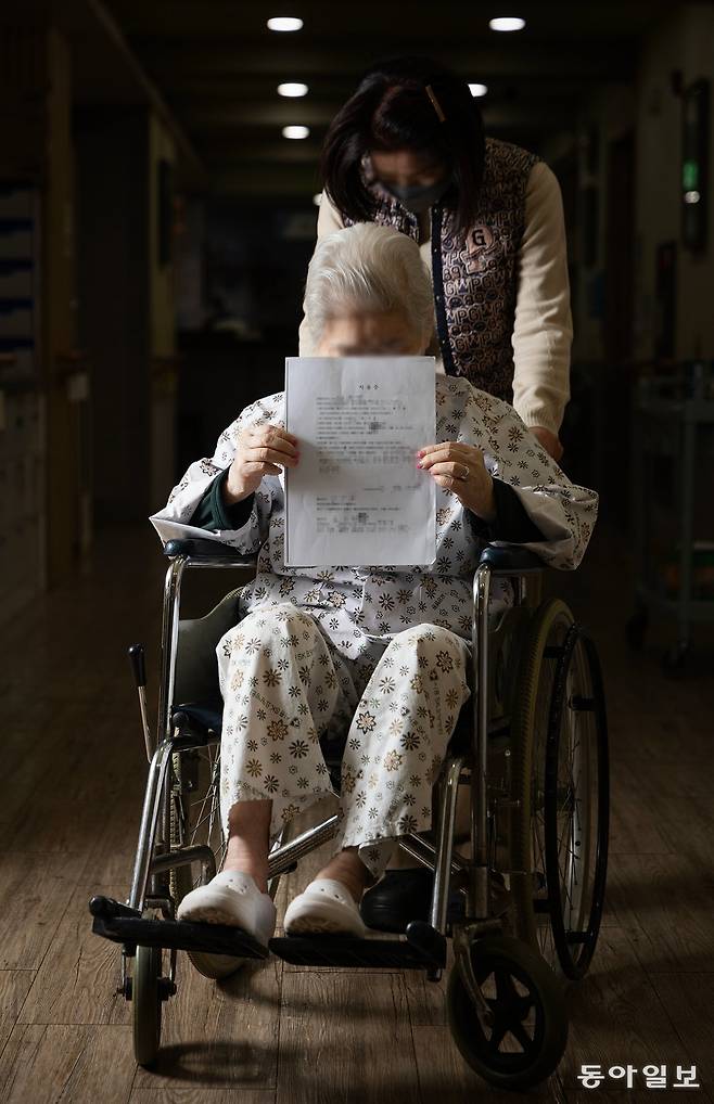 이웃에게 6억 원이 넘는 돈을 빌려줬다가 돌려받지 못한 치매 환자 서향분 씨(86)가 휠체어에 앉아 ‘차용증’을 돌려주는 모습. 그의 치매 남편은 돈을 떼인 스트레스에 시달리다가 3년 전 먼저 세상을 떠났다.