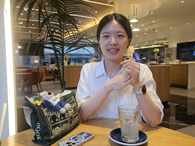 TK장녀로 유명해진 금희정씨가 지난 19일 대구 북구의 한 카페에서 영남일보 인터뷰에 응하고 있다. 금씨가 소지한 휴대전화와 가방 등엔 이재명 대통령과 더불어민주당을 지지한다는 의미를 담은 굿즈들이 달려있다. 서민지기자 mjs858@yeongnam.com