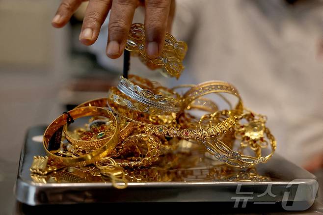 인도 아마다바드의 한 매장에서 금 세공인이 금 장신구를 저울에 달고 있다. 2025. 07. 31. ⓒ 로이터=뉴스1 ⓒ News1 양은하 기자