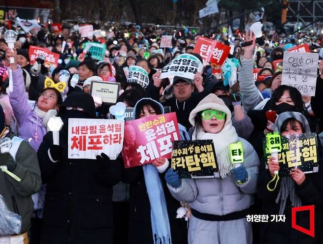 윤석열 대통령에 대한 2차 탄핵 표결에서 탄핵소추안이 가결된 후 환호하는 집회 참가자들.