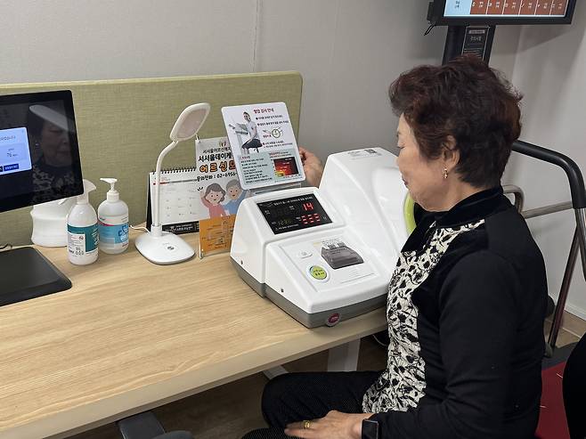 Kang Gil-ja, a Yangcheon resident, checks her blood pressure at a smart senior center in western Seoul on Nov. 4. [CHO JUNG-WOO]