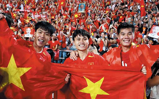 로이터 연합뉴스3관왕의 환희  18일 SEA(동남아시안) 게임 축구 금메달을 딴 베트남 23세 이하 대표팀 선수들이 국기를 흔들며 기뻐하고 있다.