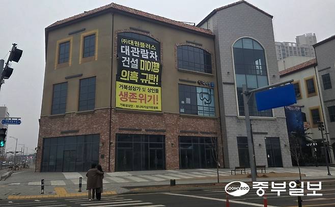 20일 오후 시흥시 거북섬동의 텅 빈 상가건물 하나에 '거북섬 대관람차' 건설 이행을 촉구하는 현수막이 걸려 있다. 최진규기자