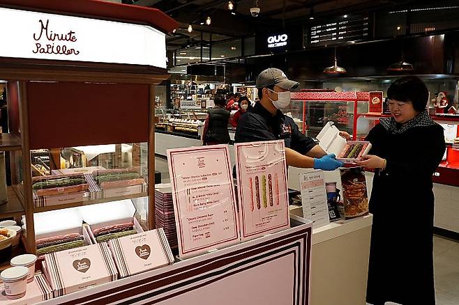 광주신세계 본관 지하 1층 '미뉴트 빠삐옹' 츄러스에서 직원이 고객에게 츄러스를 건네고 있다. 광주신세계 제공