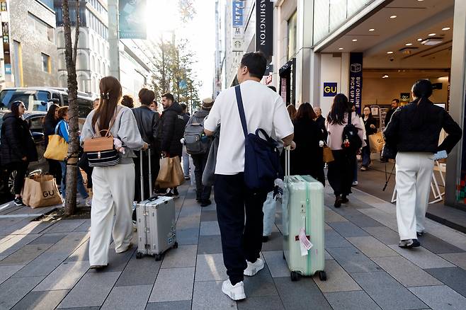 일본 도쿄 긴자 쇼핑가를 여행 가방을 든 관광객들이 걷고 있다. 기사와 직접적인 관련이 없음. /연합뉴스