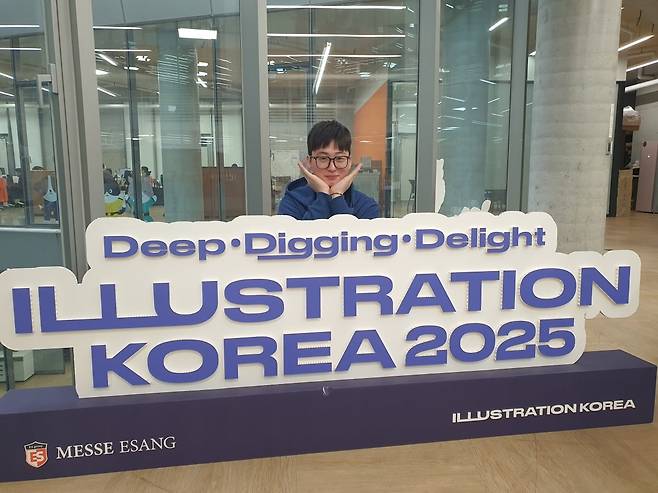 이정민 팀장이 일러스트 코리아 전시회에 대한 설명을 한 후 꽃받침을 하고 있다.  윤현주 기자