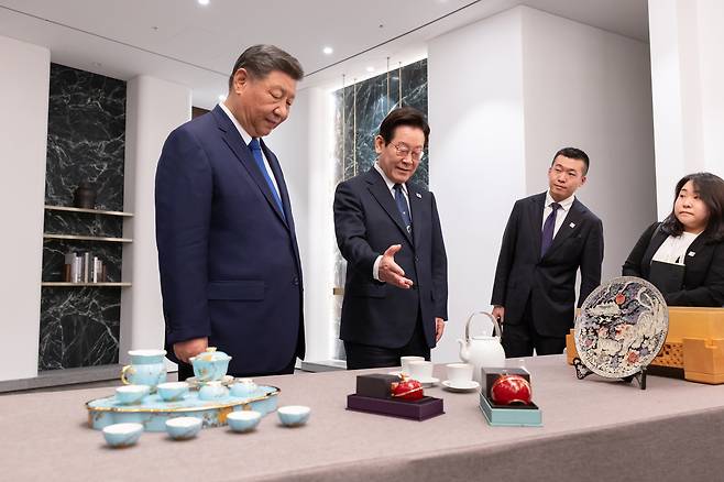 President Lee Jae Myung, second from left, and Chinese President Xi Jinping, left, smile as they exchange gifts after their summit meeting on the sidelines of the APEC gathering in Gyeongju, North Gyeongsang, on Nov. 1. [PRESIDENTIAL OFFICE]