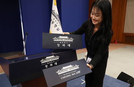 용산 대통령실 이전 작업을 본격화한 21일 청와대 브리핑룸에서 한 직원이 탈부착 업무표장을 설치하고 있다. /연합뉴스 제공