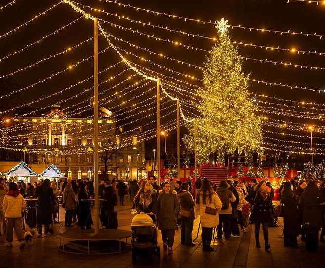 리투아니아 빌뉴스 대성당 광장 앞에 마련된 크리스마스 마켓에서 시민들이 성탄절 관련 상품을 보며 즐거운 시간을 보내고 있다. 빌뉴스=AP 뉴시스