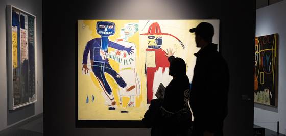 지난 19일 저녁 7시쯤 ‘바스키아 특별전’을 찾은 관객이 작품 ‘봄베로(소방관)’를 관람하고 있다. 바스키아전은 평일 낮 관람이 어려운 관객을 위해 지난 12일부터 금·토요일마다 밤 9시까지 2시간을 늘려 운영하고 있다. 전민규 기자