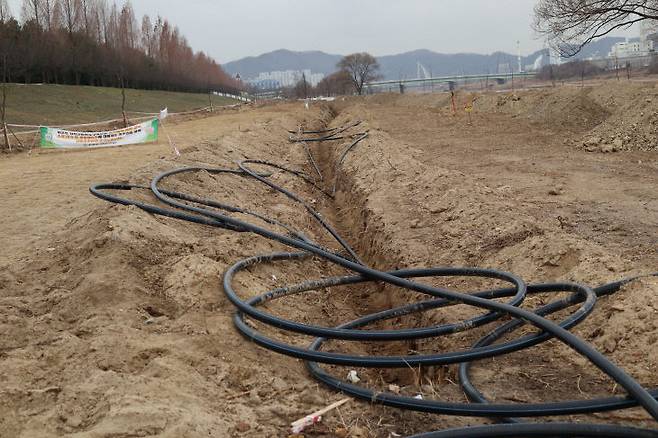 18홀 파크골프장을 만들겠다며 허가 없이 갑천을 헤집은 공사장에 깊에 땅이 파이고 스프링클러 설치를 위한 호스와 놓여 있다. &nbsp;&nbsp;(사진=임병안 기자)