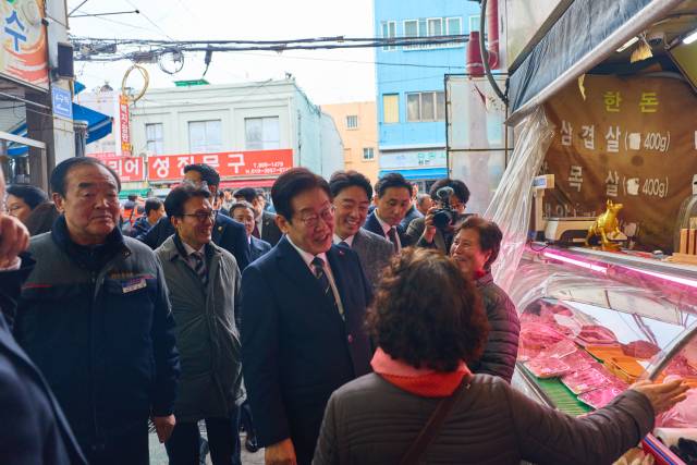 이재명 대통령이 23일 해양수산부 청사에서 국무회의를 마친 뒤 부산 부산진구 부전시장을 찾아 상인들과 이야기를 나누고 있다. 연합뉴스