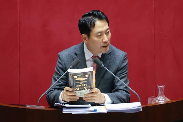 장동혁 국민의힘 대표가 23일 국회에서 열린 12월 임시국회 본회의에서 12·3 윤석열 비상계엄 등에 대한 전담재판부 설치 및 제보자 보호 등에 관한 특별법에 대한 무제한 토론을 하며 하이에크가 쓴 자유헌정론을 들어보이고 있다. [연합뉴스]