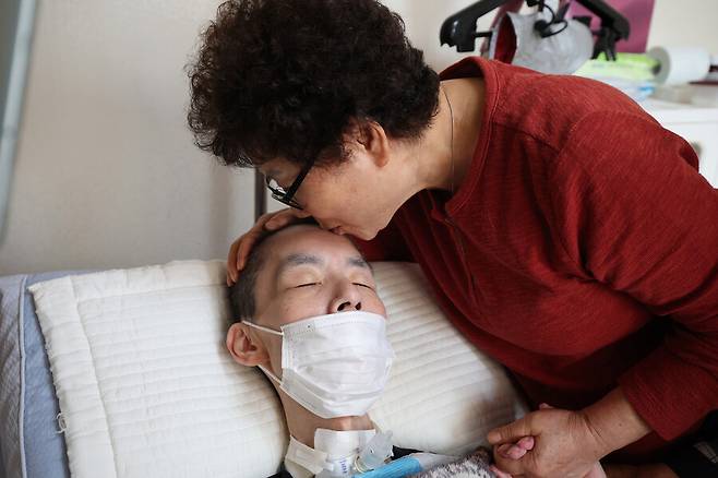 지난 10일 오후 충남 보령시 자택에서 어머니 박정자씨가 뇌병변 중증장애로 혼자 힘으로 움직이기 어려운 김선호씨의 이마에 입을 맞추고 있다. 최현수 기자 emd@hani.co.kr