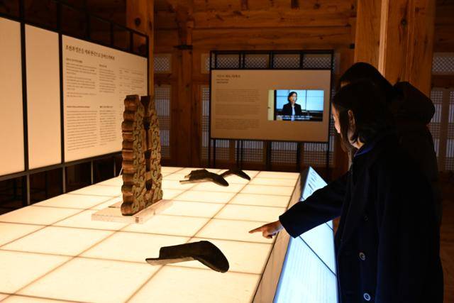 23일 서울 종로구 경복궁 계조당에서 열린 특별전 '돌아온 관월당: 시간을 걷다' 개막행사에서 관람객이 관월당의 용문 암막새 기와를 관람하고 있다. 국가유산청 제공