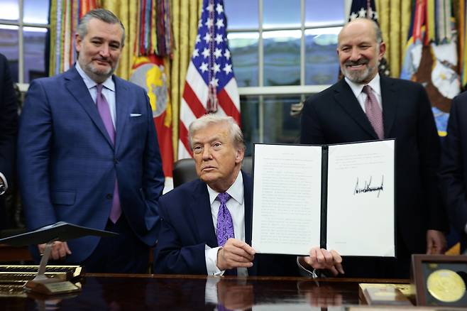 U.S. President Donald Trump , center, delivers remarks with U.S. Senator Ted Cruz, left, and U.S. Secretary of Commerce Howard Lutnick during a signing ceremony on artificial intelligence in the Oval Office at the White House in Washington on Dec. 11. [EPA/YONHAP]