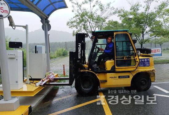 ▲ 울산 중구는 지난 2019년 태화강 인근 하상주차장에 이동형 데크프레임을 도입했다. 사진은 침수 대비를 위해 지게차로 주차관제기를 나르는 모습. 중구청 제공