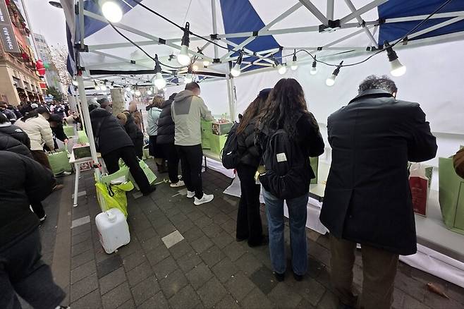 24일 새벽부터 줄을 서 오전 10시30분께 ‘딸기시루’ 사기에 성공한 손님들이 먼 거리 이동을 위해 성심당 케익부띠끄 본점 옆쪽에 설치된 천막에서 방금 구매한 케이크를 보냉가방에 포장하고 있다. 최예린 기자