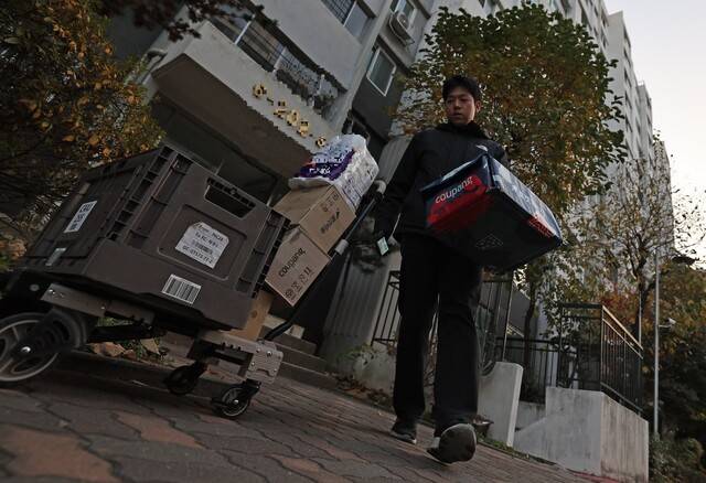 류석우 기자가 서울 강남구의 한 아파트에서 쿠팡의 프레시백을 회수한 뒤 건물을 나오고 있다. 아직 배송을 기다리는 물품이 끌개에 가득하다. 이종근 선임기자 root2@hani.co.kr