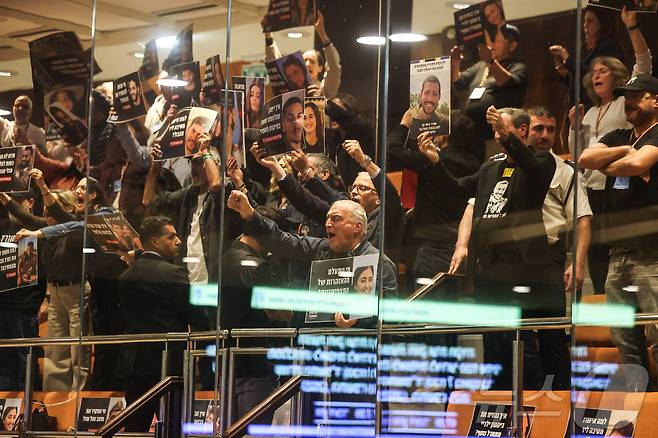 24일(현지시간) 이스라엘 예루살렘에 있는 이스라엘 의회 본회의장 상단에서 '10월 위원회(October Council)' 회원들이 시위를 벌이고 있다. 전직 인질들과 희생자 가족들로 구성된 이 단체는 2023년 10월 7일 하마스의 공격을 초래한 안보 실패에 대해 독립적인 국가조사위원회 설치를 요구하고 있다. 2025.12.24 ⓒ 로이터=뉴스1 ⓒ News1 최종일 선임기자