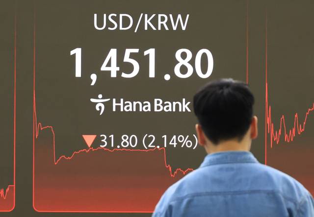 24일 서울 중구 하나은행 본점에서 직원들이 증시와 환율을 모니터하고 있다. 이날 원·달러 환율은 33.8원 내린 1449.8원으로 3년 1개월 만에 최대폭 하락했다. 연합뉴스