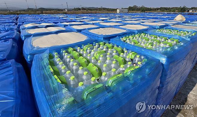 야외 주차장서 햇볕·비바람에 노출된 기부받은 생수 [연합뉴스 자료사진]