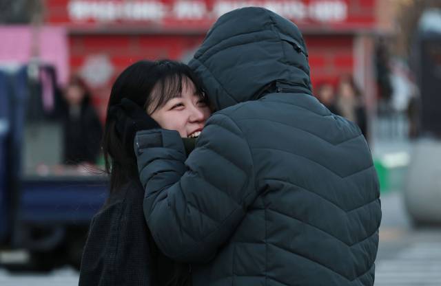 전국 대부분 지역에 '한파특보'가 발효되면서 올겨울 가장 추운 날씨를 보이는 26일 서울 종로구 광화문 세종대로사거리에서 한 연인이 서로 추위를 녹여주고 있다. 연합뉴스