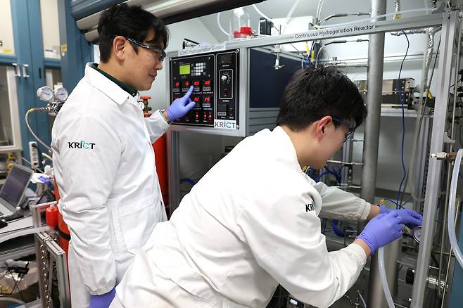 한국화학연구원 박지훈(왼쪽) CO₂에너지연구센터장이 자체제작 및 구축한 일일최대 5㎏의 수소를 저장 및 추출할 수 있는 반응장비를 점검하고 있다. [한국화학연구원 제공]