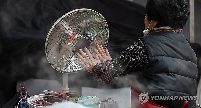 손 녹이는 상인 [연합뉴스 자료사진]