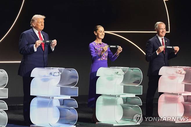 지난 5일 미국 워싱턴DC의 케네디센터에서 열린 북중미 월드컵 조 추첨식 President Donald Trump, Mexican President Claudia Sheinbaum and Canadian Prime Minister Mark Carney hold their countries' cards during the draw for the 2026 soccer World Cup at the Kennedy Center in Washington, Friday, Dec. 5, 2025. (AP Photo/Stephanie Scarbrough, Pool) POOL PHOTO