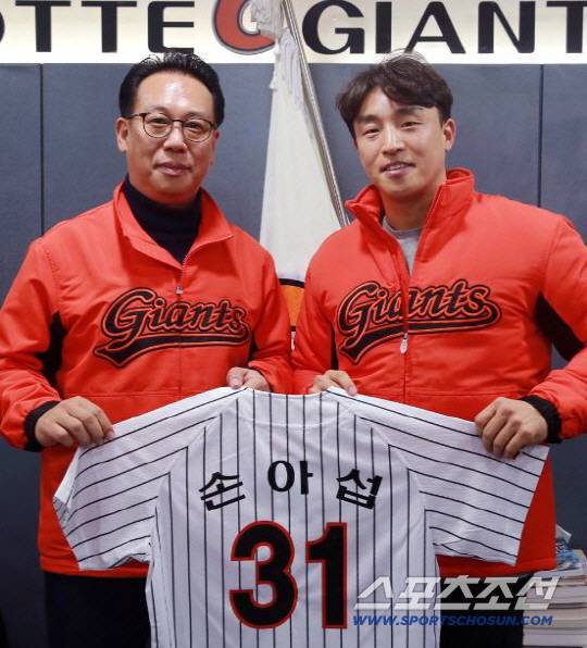 롯데 자이언츠가 내부 FA 손아섭과 4년 98억원에 재계약했다. 계약서에 사인을 한 뒤 이윤원 단장(왼쪽)과 손아섭이 31번이 적힌 그의 유니폼을 들고 포즈를 취했다. 사진제공=롯데 자이언츠