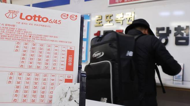 서울 노원구에 위치한 복권 판매점을 찾은 시민이 복권을 구매하고 있다. /뉴스1