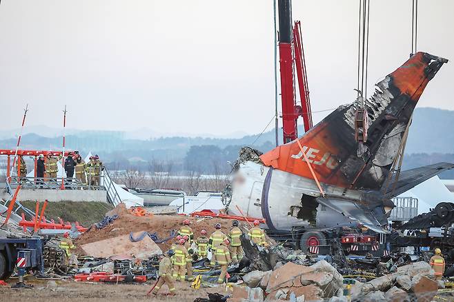 A crane lifts the tail section of crashed Jeju Air's B737-800 at Muan International Airport in South Jeolla on Jan. 3, five days after the accident. [NEWS1]