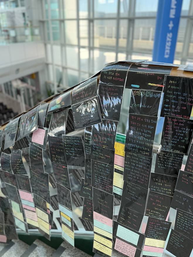 Handwritten letters delivering condolence to the victims of the Jeju Air crash cover the glass railing on a staircase at Muan International Airport in South Jeolla on Dec. 22. [LEE SOO-JUNG]