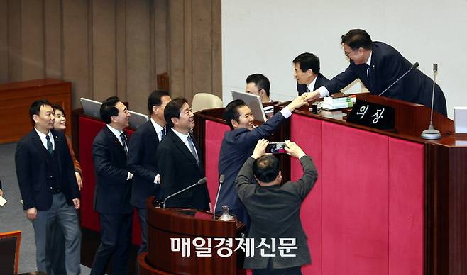 정청래 더불어민주당 대표(단상 아래 오른쪽 둘째)가 24일 국회 본회의에서 민주당 의원들과 함께 정보통신망법 개정안에 대한 필리버스터 종결 투표를 마치고 우원식 국회의장과 악수하고 있다. 김재훈 기자