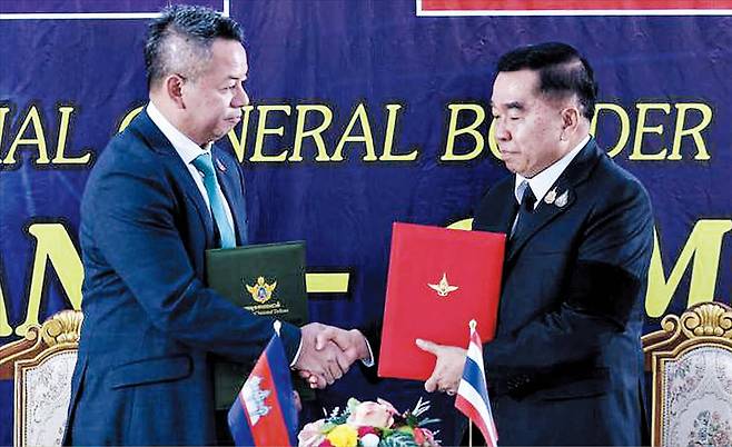 27일 오후 태국 찬타부리주 프룸-반팍카드 국경검문소에서 낫타폰 낙파니트(오른쪽) 태국 국방 장관과 티아 세하 캄보디아 부총리 겸 국방 장관이 양국 간 휴전 합의 후 악수하고 있다. 양국은 이날 낮 12시를 기해 지난 7일부터 이어진 전쟁을 멈추기로 합의했다./AFP 연합뉴스